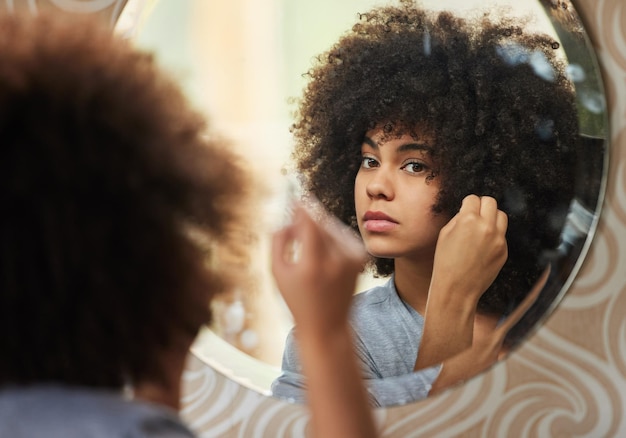 Vita elettrica e anima ritratto di una bella donna che si guarda allo specchio mentre si trucca a casa