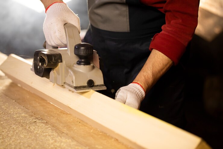 Photo electric planer bevels off wooden workpiece on workbench