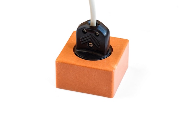 Electric plug inserted into an electrical outlet on a white background