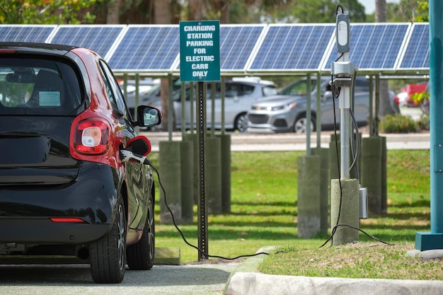 街の通りに駐車された太陽光再生可能電源からの電気で充電する電気プラグインカー