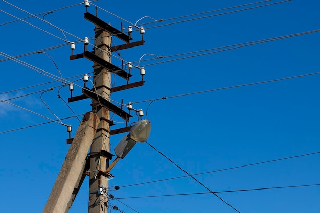 Un palo elettrico con fili e un lampione stradale contro il cielo blu durante il giorno