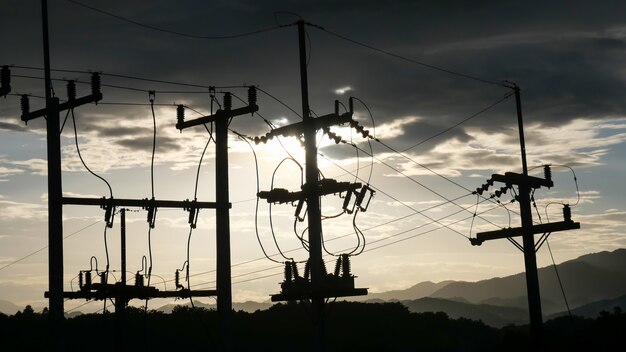 I poli elettrici contrastano con il cielo al tramonto la sera.