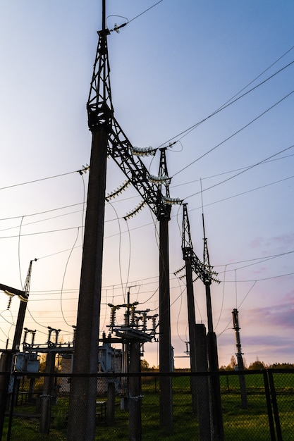 Photo electric power substation at sunset. high voltage transformer and power lines. electricity supply