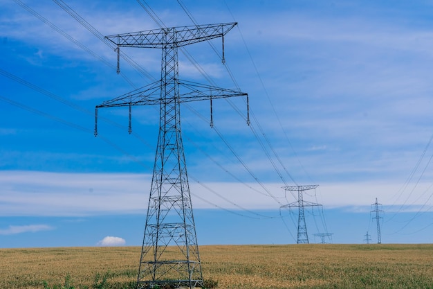 Electric power transmission lines at sky background, an autumn field