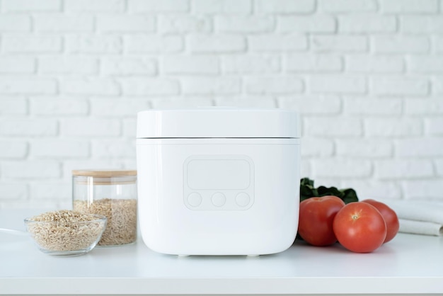 Electric rice cooker on wooden countertop in the kitchen