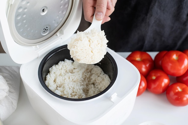 Electric rice cooker on wooden countertop in the kitchen