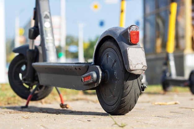 Photo electric scooter standing on asphalt in sunlight close up