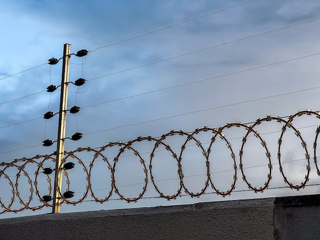 Electric security fence on a wall with a dramatic sky in the background