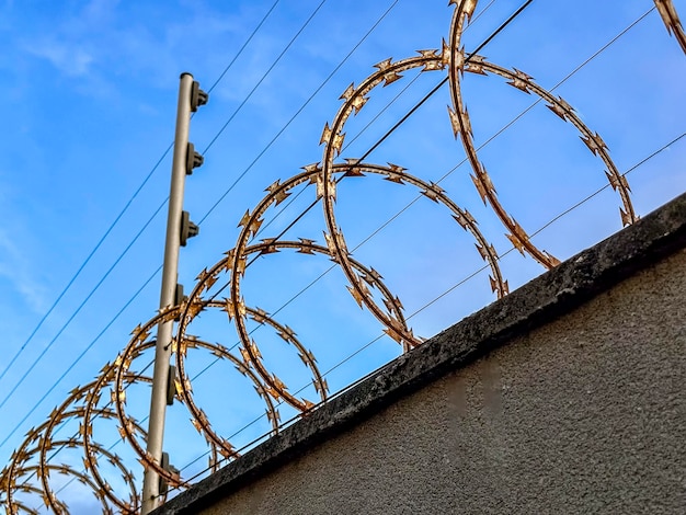 Electric security fence on a wall with a dramatic sky in the background