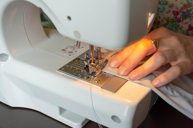 Electric sewing machine seamstress hands working with sewing machine tailoring sewing machine needle