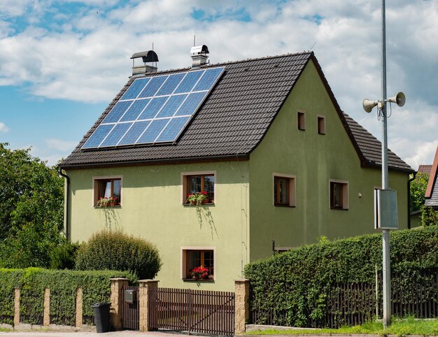 Electric solar panels on roof of nice modern house rays of sun reflting in blue cells of panels