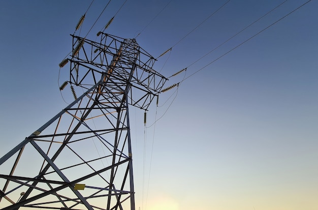 Electric station with wires standing on background of sunset closeup