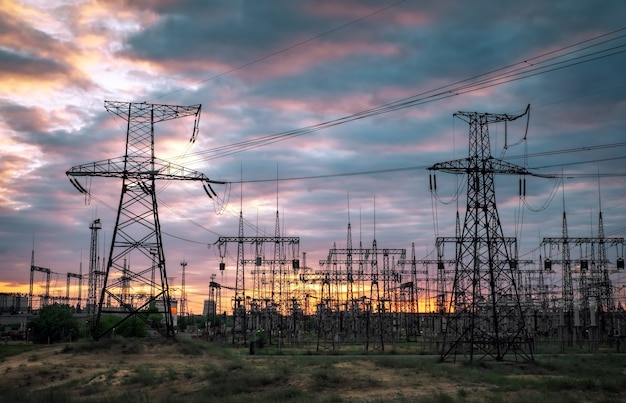 Sottostazione elettrica con linee elettriche e trasformatori, al tramonto