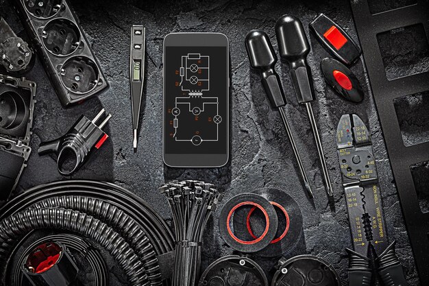 Electric Tools Set With Blueprint On Smartphone Display On Black Stone Background