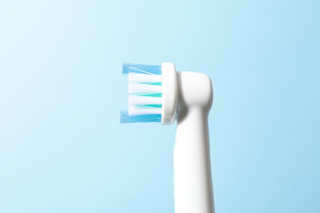 Photo electric toothbrush on light blue background close up