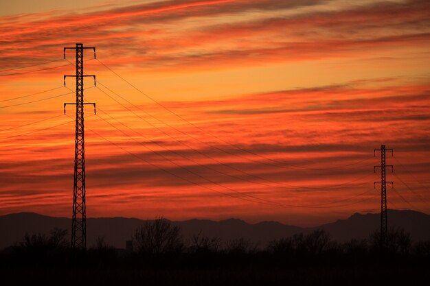 Electric towers backlit in a red sunset