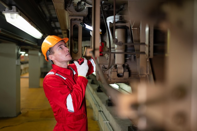 Electric train engineer use a walkietalkie to inspect electric train machinery