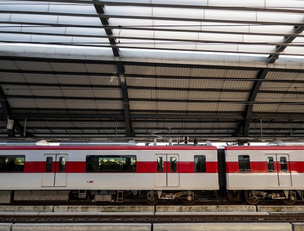 The electric train stops to pick up passengers at a suburban station