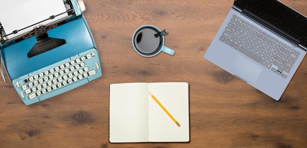 Electric typewriter and laptop on wood background