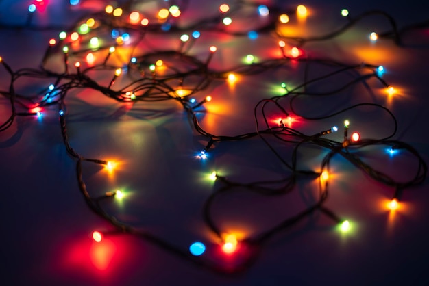 The electric wire messy garland on the color surface of table in dark place
