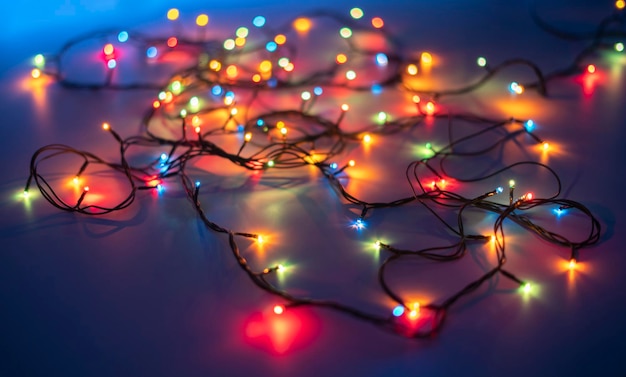 The electric wire messy garland on the color surface of table in dark place