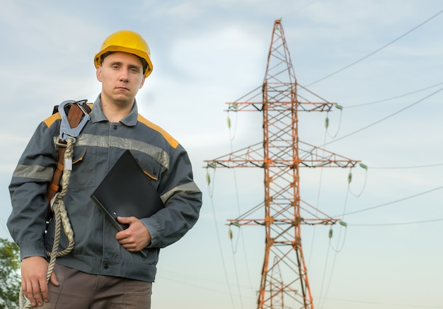 Un ingegnere elettrico sullo sfondo di una linea elettrica