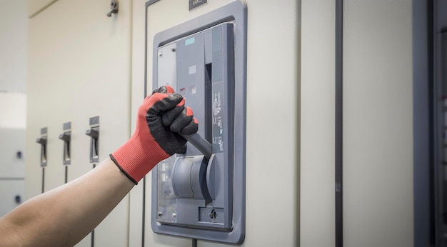 Electrical engineer checking the operation of electrical control cabinet, maintenance concept.