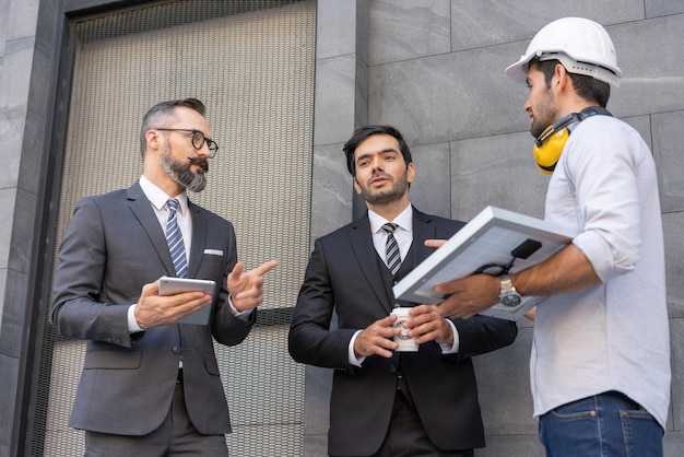 Electrical engineer with businessman discussing a plan solar cell panel project in construction site