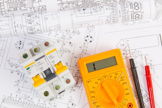 Electrical engineering drawings, modular circuit breaker and digital multimeter. Electrical network protection and switching.