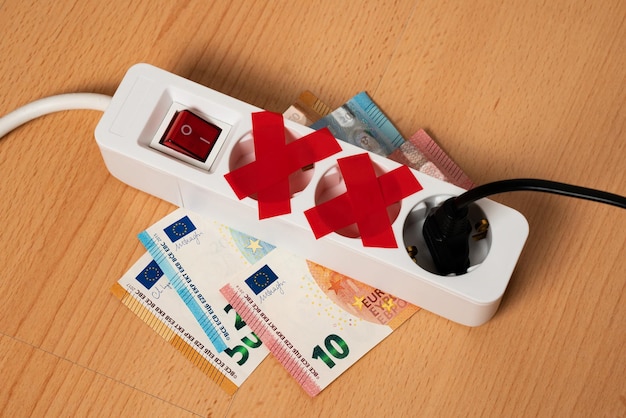 Electrical extension cord with three outlets lies on banknotes Two sockets sealed with red electrical tape