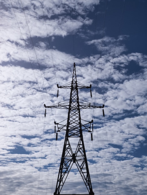 Электрическая высоковольтная башня на фоне облачного неба