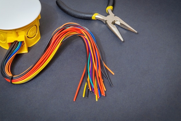 電気接続プロセスで通常使用される黒いスペースにワイヤーとツールを備えた電気接続箱