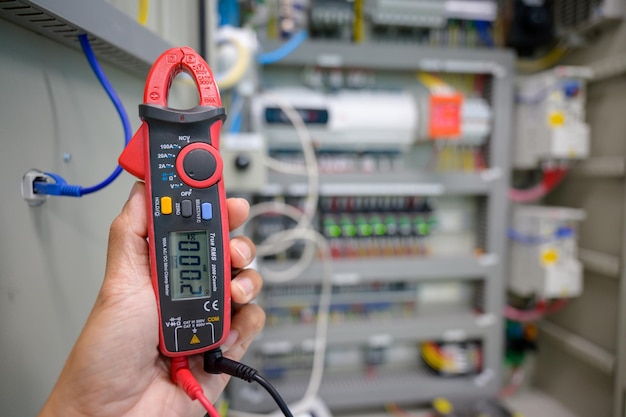 Electrical measurements with a multimeter tester industrial electricity Test the voltage on the automatic control box using a digital voltmeter. electric background