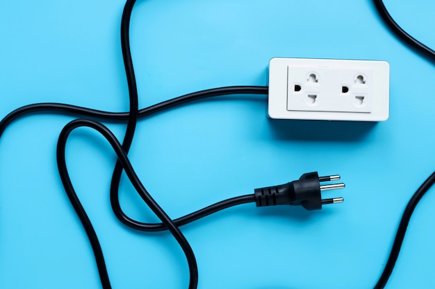 Electrical power strip and plug on blue surface