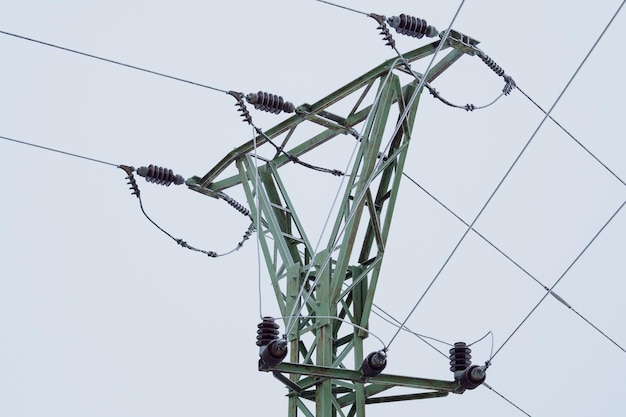 Electrical pylons high voltage wires in winter covered with frost