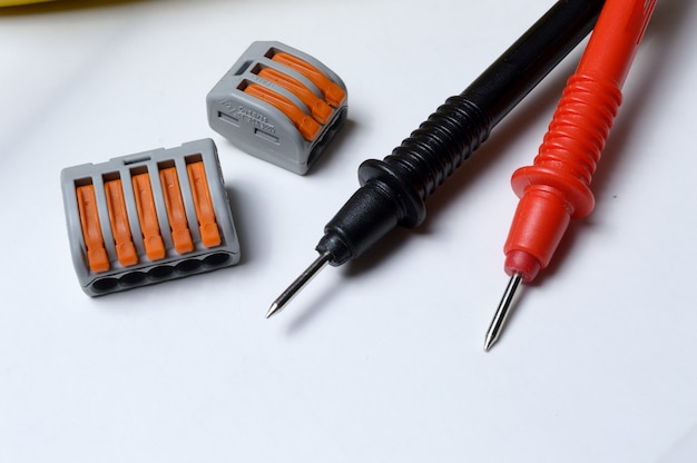 Electrical terminal blocks and multimeter probes on a light background. close-up.