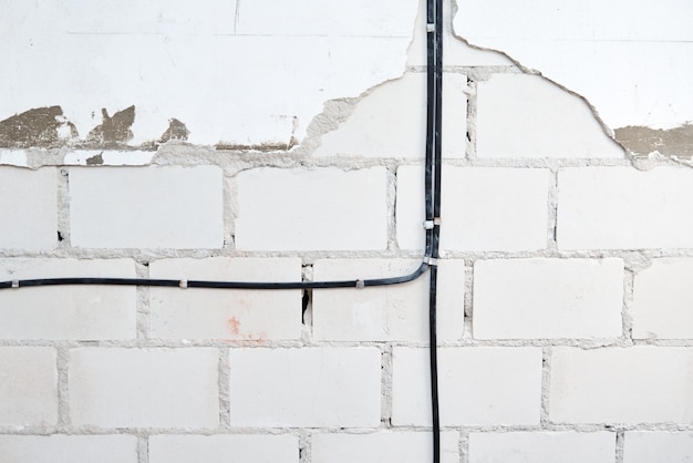 Electrical wires on a brick wall. Cable laying