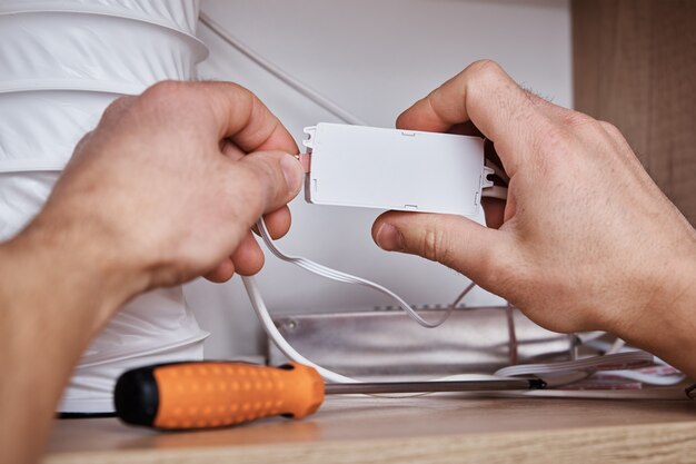 電気技師は食器棚のワイヤーを接続します