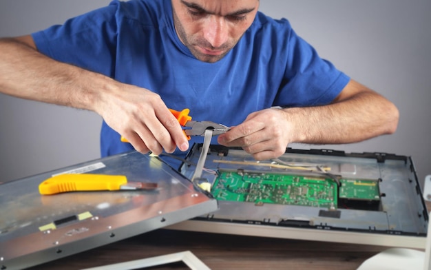 Electrician engineer repairing computer monitor