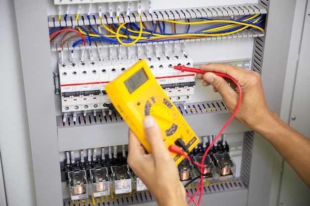 Electrician engineer work tester measuring voltage and current\
of power electric line