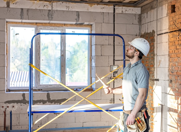 An electrician examines a construction drawing at a work site.