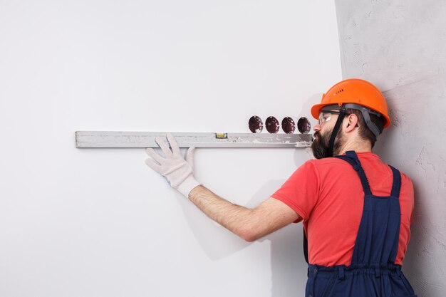 Electrician in helmet installs sockets