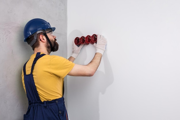 Electrician in helmet installs sockets