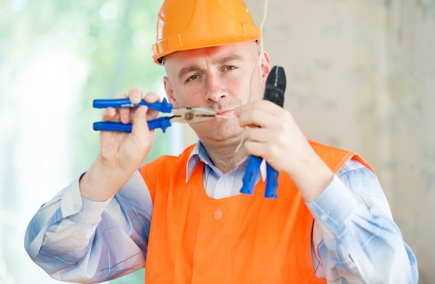 Electrician a helmet repairing ceiling wiring in the house