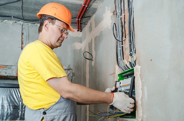 The electrician installing the fuses in the switch box