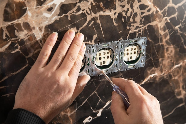 Electrician installing a wall socket at home