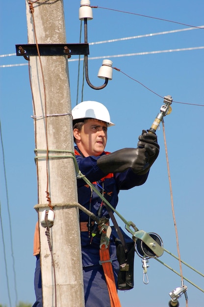 電気技師は、修理する前に送電線にアースを取り付けます