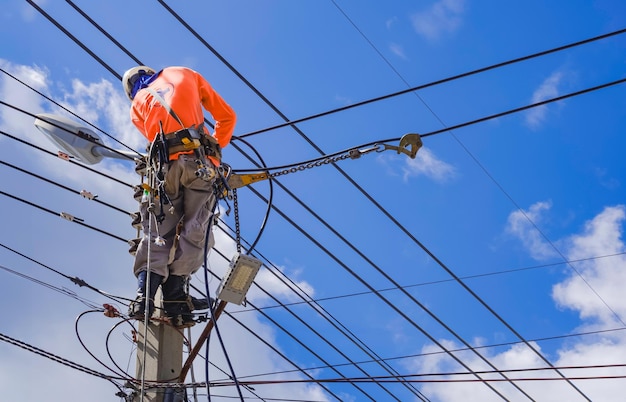 Electrician is Installing Cable lines and Electrical system on new Electric Power Pole