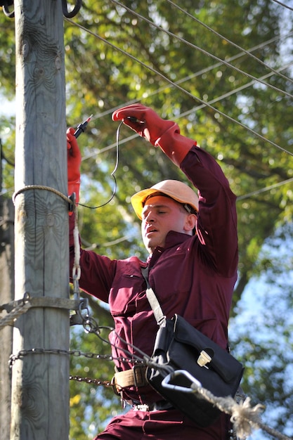 The electrician measures the voltage on the power line before repairing it