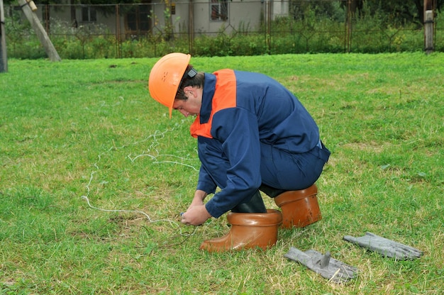 An electrician repairs a break in the wire of the overhead transmission line